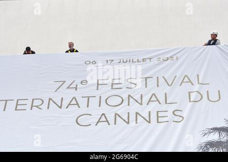 Cannes Film Festival 2021: Das Plakat für die 74. FIF fand auf dem Giebel des Palais des Festivals statt. Am frühen Sonntagmorgen haben die Passanten nicht versäumt, an diesem traditionellen Moment teilzunehmen, der den Beginn der Feierlichkeiten markiert. (Foto von Lionel Urman/Sipa USA) Stockfoto