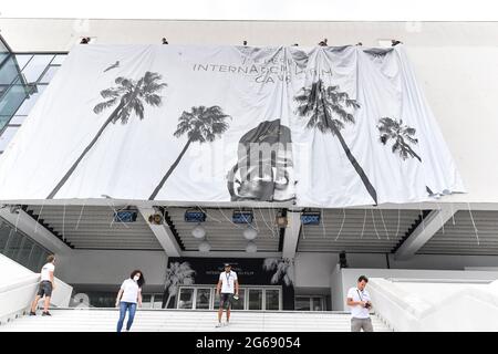 Cannes Film Festival 2021: Das Plakat für die 74. FIF fand auf dem Giebel des Palais des Festivals statt. Am frühen Sonntagmorgen haben die Passanten nicht versäumt, an diesem traditionellen Moment teilzunehmen, der den Beginn der Feierlichkeiten markiert. (Foto von Lionel Urman/Sipa USA) Stockfoto