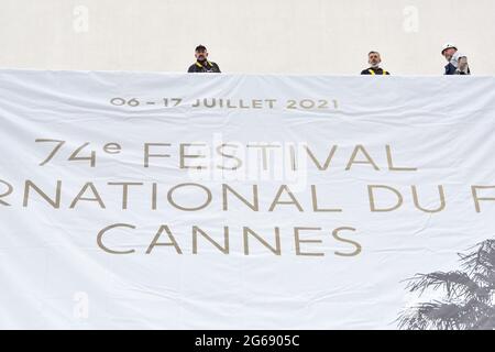 Cannes Film Festival 2021: Das Plakat für die 74. FIF fand auf dem Giebel des Palais des Festivals statt. Am frühen Sonntagmorgen haben die Passanten nicht versäumt, an diesem traditionellen Moment teilzunehmen, der den Beginn der Feierlichkeiten markiert. (Foto von Lionel Urman/Sipa USA) Stockfoto