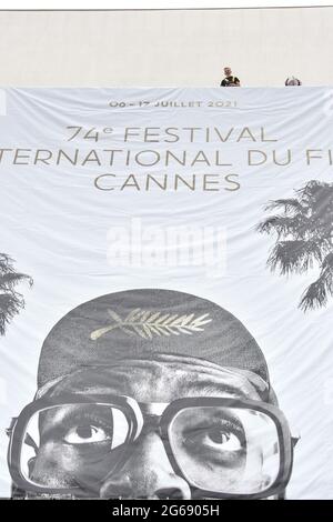 Cannes Film Festival 2021: Das Plakat für die 74. FIF fand auf dem Giebel des Palais des Festivals statt. Am frühen Sonntagmorgen haben die Passanten nicht versäumt, an diesem traditionellen Moment teilzunehmen, der den Beginn der Feierlichkeiten markiert. (Foto von Lionel Urman/Sipa USA) Stockfoto