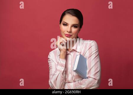Schöne junge Frau auf rotem Banner Hintergrund. Menschen aufrichtige Emotionen Lifestyle-Konzept Stockfoto