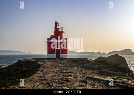 Alter roter Leuchtturm in Punta Robaleira und Islas Cies von Cabo Home, Rias Baixas, Galicien, Spanien Stockfoto