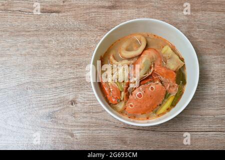 Gekochte Blumenkrabben und Garnelen verbinden Tintenfisch mit Dolly-Fisch in einer thailändischen, würzigen Suppe oder Fisch mit tom Yum auf der Schüssel Stockfoto