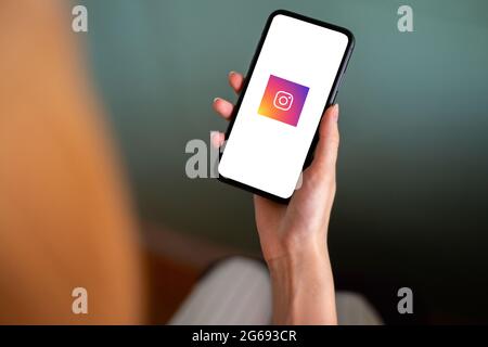 Riga, Lettland - 3. Juli 2021: Frau mit Mobiltelefon und Instagram-Logo auf dem Bildschirm Stockfoto