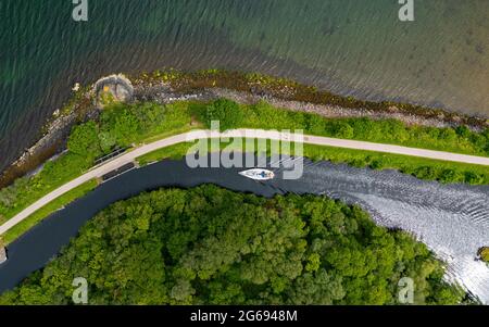 Luftaufnahme von der Drohne einer Yacht, die auf dem Crinan Canal in Crinan in Argyll & Bute, Schottland, Großbritannien, navigiert Stockfoto