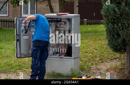 Installation von Arbeiter- und Glasfaserkabeln auf der Straße Stockfoto