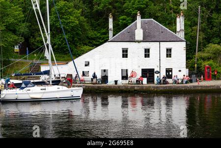 Blick auf das weiß getünchte Café des Coffee Shop neben dem Kanalbecken am Crinan Canal in Crinan in Argyll & Bute, Schottland, Großbritannien Stockfoto