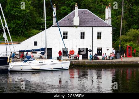 Blick auf das weiß getünchte Café des Coffee Shop neben dem Kanalbecken am Crinan Canal in Crinan in Argyll & Bute, Schottland, Großbritannien Stockfoto