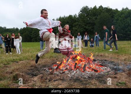 Minsk, Weißrussland. Juli 2021. Während der Feierlichkeiten zum Ivan-Kupala-Fest in Minsk, Weißrussland, am 3. Juli 2021, springen Menschen über ein Lagerfeuer. Quelle: Henadz Zhinkov/Xinhua/Alamy Live News Stockfoto