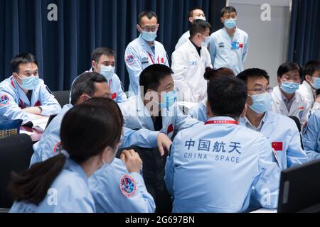 (210704) -- PEKING, 4. Juli 2021 (Xinhua) -- Technische Mitarbeiter arbeiten im Beijing Aerospace Control Center in Peking, der Hauptstadt Chinas, 4. Juli 2021. Chinesische Astronauten haben am Sonntag Extravehicular-Aktivitäten (EVAs) abgeschlossen und sind nach Angaben der China Manned Space Agency (CMSA) zum Kernmodul der Raumstation Tianhe zurückgekehrt. Die ersten EVAs während des Baus der Raumstation des Landes seien ein voller Erfolg, erklärte die CMSA. Die Shenzhou-12 Raumschiffcrew hat nach etwa 7 Stunden außerplanmäßiger Aktivitäten (EVAs) alle geplanten Aufgaben und die Astrona abgeschlossen Stockfoto