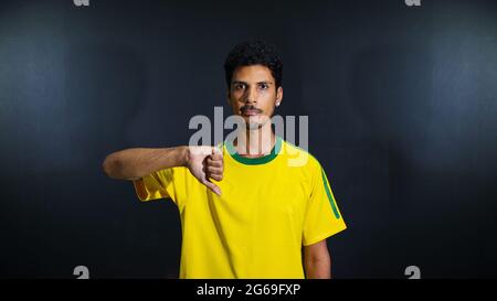 Olympics verrückt und traurig schwarzen Mann Fan in Uniform isoliert auf schwarzem Hintergrund. Platz für Text. Stockfoto