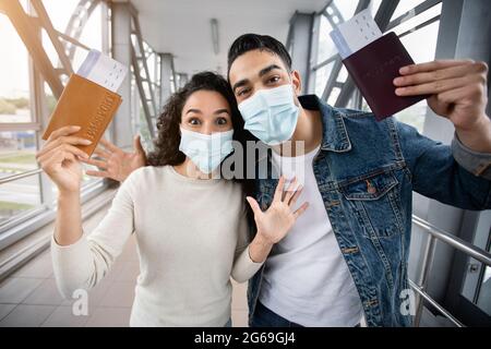 Urlaub Endlich. Aufgeregt Paar Trägt Masken In Airport Holding Pässe Und Tickets Stockfoto