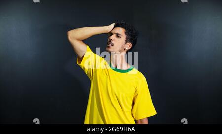 Olympics verrückt und traurig schwarzen Mann Fan in Uniform isoliert auf schwarzem Hintergrund. Platz für Text. Stockfoto