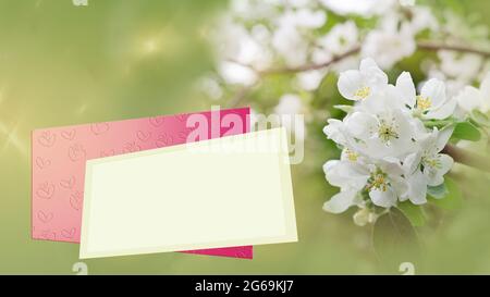 Blühende Äste auf einem defokussierten Hintergrund, ein Textrahmen und ein Umschlag mit geprägtem Herz Stockfoto
