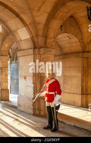 Demontierter Soldat mit traditioneller roter Uniform, der bei der Horse Guard Parade in London Dienst stand. Stockfoto