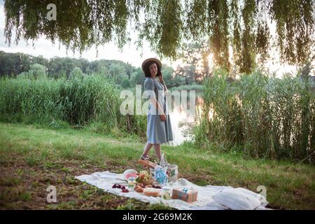 Eine junge Frau, die in einem Park picknickt Stockfoto