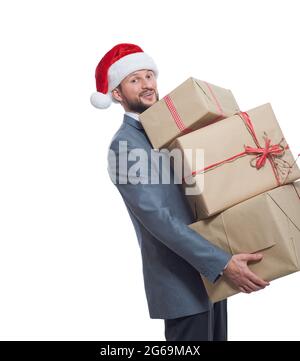 Hübscher junger Mann in einem Anzug mit Weihnachtsmütze und einem Stapel Geschenke Stockfoto