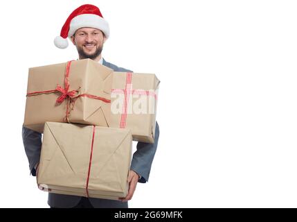 Hübscher junger Mann in einem Anzug mit Weihnachtsmütze und einem Stapel Geschenke Stockfoto