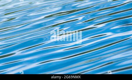 Abstrakte Wellen auf der Oberfläche des blauen Wassers, entspannende Oberfläche und Form der blauen Wellen. Bewegungsunschärfe. Stockfoto