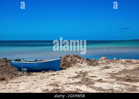 Herrliche Aussicht auf die Mittelmeerküste mit Birkenwasser, weißem Sandstrand und einem Fischerboot Stockfoto