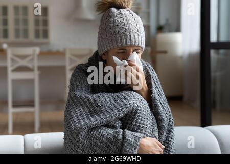 Ungesunde junge Frau, die an laufender Nase leidet. Stockfoto