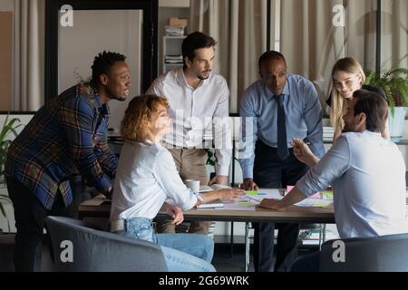 Lächelnde Kollegen beim Brainstorming mit Finanzdokumenten Stockfoto