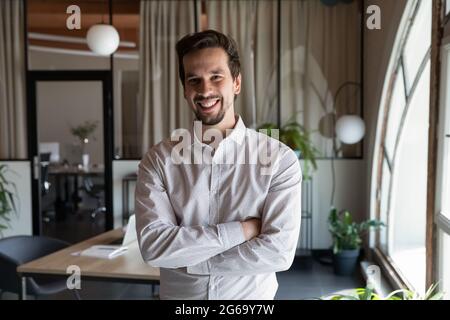 Porträt eines lächelnden Geschäftsmannes mit gekreuzten Armen Stockfoto