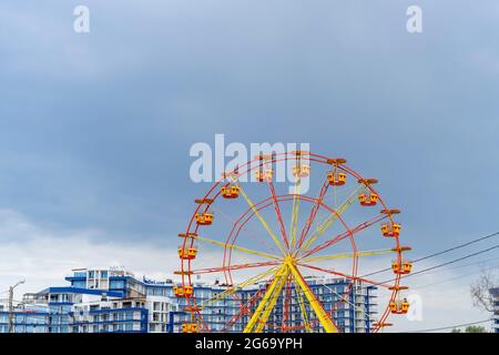 Sewastopol, Russland-17. Juni 2021: Riesenrad auf dem Hintergrund des Mehrfamilienhauses Stockfoto