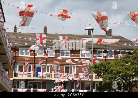 London, Großbritannien. Juli 2021. Rot-weiße St George Flaggen ragen über dem Kirby Estate in Bermondsey.Kirby Estate in Bermondsey ist mit über 400 St George Flaggen zur Unterstützung des englischen Teams für das verzögerte Euro 2020 Fußballturnier bedeckt. Eine Tradition der Gutsbewohner seit 2012.das englische Team besiegte die Ukraine 4-0 in Rom am 3. Juli und erreichte damit das Halbfinale gegen Dänemark, das am 6. Juli in Wembley angesetzt ist. (Foto von David Mbiyu/SOPA Images/Sipa USA) Quelle: SIPA USA/Alamy Live News Stockfoto