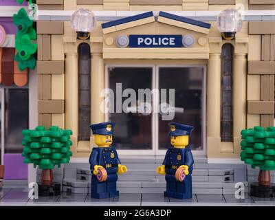 Tambow, Russische Föderation - 02. Juli 2021 zwei Lego-Polizisten, die vor ihrer Polizeistation stehen und Donuts essen. Stockfoto