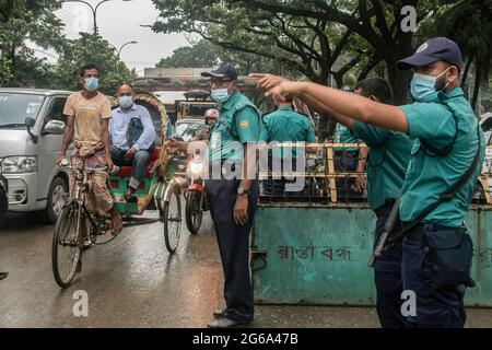 Dhaka, Bangladesch. Juli 2021. Polizeibeamte überwachen während einer strikten Sperre die Volksbewegung an einem Kontrollposten in Dhaka. Die Regierung Bangladeschs hat eine landesweite Sperrung mit strengen Einschränkungen verhängt. Niemand darf während der Sperrung das Haus ohne Notfälle verlassen. Nur die Rettungsdienste dürfen geöffnet werden. (Foto: Sazzad Hossain/SOPA Images/Sipa USA) Quelle: SIPA USA/Alamy Live News Stockfoto