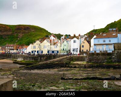 Staithes North Yorkshire Strand und Strandpromenade über die Bucht an einem trüben, bewölkten Sommertag Stockfoto