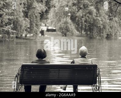 Vintage monochromes Bild mit zwei Senioren auf einer Bank in einem Park sitzen. Stockfoto