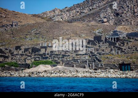 Griechenland. Delos die heilige Insel der Kykladen, Gesamtansicht vom Meer. Alte Zivilisation Ruinen am Meer, archäologische Stätte auf UNESCO-Weltkulturerbe Stockfoto