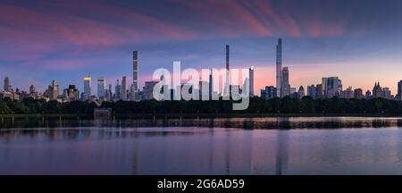 Skyline von New York City. Midtown Manhattan Wolkenkratzer vom Central Park Reservoir at Dusk. Blick am Abend auf die Milliardäre, die in superhohen Luxusgebäuden rudern Stockfoto