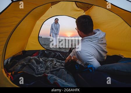 Paar schlafen im Zelt Blick auf Sonnenaufgang. Wanderkonzept. Strand Stockfoto