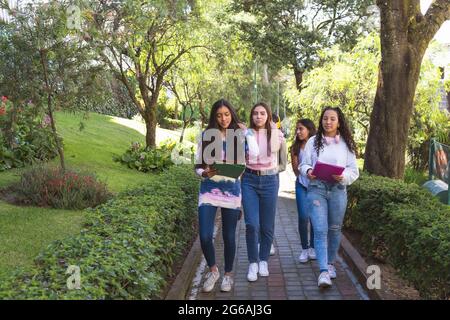 Eine Gruppe von jungen Latinx-Freunden geht mit ihren Rucksäcken auf dem Weg zum Unterricht. Bildung und Teens Konzept Stockfoto