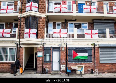 London, Großbritannien. Juli 2021. Eine Frau wird auf dem Anwesen Kirby in Bermondsey im Südosten Londons gesehen. Ein Wohngebiet wurde mit englischen Flaggen bedeckt, als sich das englische Team in das Halbfinale der Europameisterschaft 2021 vorstellt. Kredit: SOPA Images Limited/Alamy Live Nachrichten Stockfoto