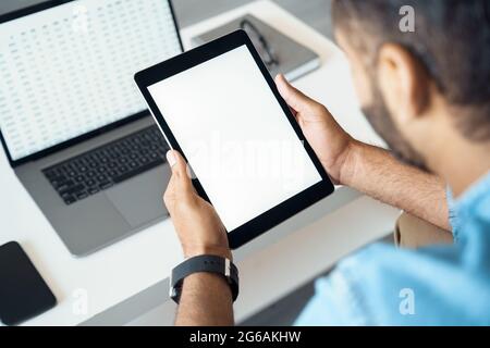 Nahaufnahme über die Schulter auf dem leeren Bildschirm des mobilen Tablet-pcs in der männlichen Hand Stockfoto