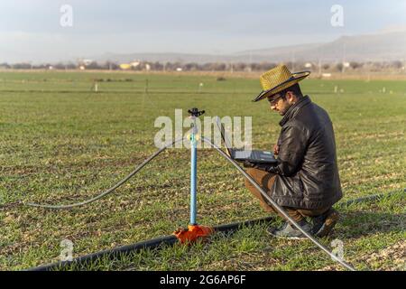 Ein intelligentes Landwirtschaftskonzept - ein Landwirt auf dem Feld, der moderne Technologien nutzt, um landwirtschaftliche Arbeitsplätze zu schaffen Stockfoto