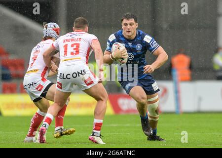 Liam Byrne (19) von Wigan Warriors sucht einen Weg hinter Morgan Knowles (13) von St. Helens und Theo Fages (7) von St. Helens Stockfoto