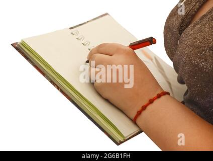 Die Hand des Mädchens hält einen Stift und schreibt in einem Notizbuch Platz für Text und Design Nahaufnahme. Stockfoto