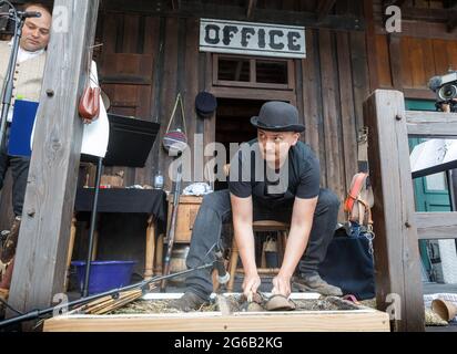 Bad Segeberg, Deutschland. Juni 2021. Während die Schauspieler auf der Bühne ihre Zeilen sprechen, erzeugt der Noisemaker Marc Franciso im Hintergrund das Geräusch von Fußstapfen in einem Kiesbett und das Klappern von Pferden mit Kokosnussschalen. Quelle: Markus Scholz/dpa/Alamy Live News Stockfoto