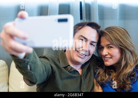 Lächelnder reifer Mann und Frau, die ein Selfie machen. Stockfoto