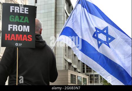 London, Großbritannien. Mai 2021. Ein Protestler hält ein Plakat mit der Aufschrift "Free Gaza from Hamas" und eine israelische Flagge während des Protestes.Pro-israelische Demonstranten versammeln sich vor der israelischen Botschaft in der High Street Kensington, um den am 21. Mai vereinbarten Waffenstillstand zu unterstützen. Eine kleine Gruppe von Palästinensern kam zur Gegendemonstration der israelischen Demonstration, doch die Polizei bildete eine Absperrung zwischen den beiden Massen, um jegliche Gewalt zu vermeiden. (Foto von Martin Pope/ SOPA Images/Sipa USA) Quelle: SIPA USA/Alamy Live News Stockfoto