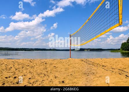 Beachvolleyballplatz neben dem See und Wald an einem sonnigen Tag Stockfoto