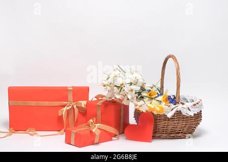 Schöne Grußkarte mit Geschenken und einem Korb mit Narzissen Blumen. Alles gute zum Muttertag, Familientag, Geburtstag, Jubiläum mit einem Ort zum Text Stockfoto