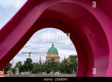 Potsdam, Deutschland. Juni 2021. Blick durch künstlerisch gestaltete farbige Figuren im Garten Lustgarten in der Innenstadt auf die Nikolaikirche am Alten Markt, die von Baukräne umgeben ist. Quelle: Jens Kalaene/dpa-Zentralbild/ZB/dpa/Alamy Live News Stockfoto