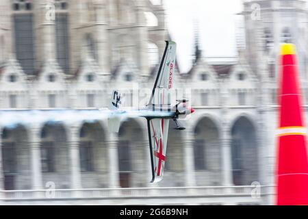 Budapest, Ungarn - 23. Juni 2018: Ben Murphy in Zivko Edge 540 fliegt beim Red Bull Air Race mit hoher Geschwindigkeit durch das ungarische Parlamentsgebäude Stockfoto