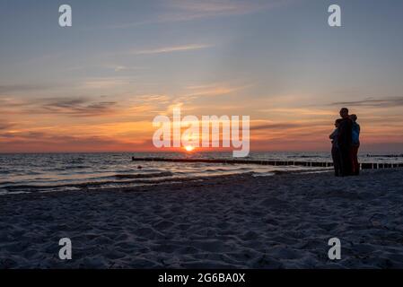 Hiddensee, Deutschland. Juni 2021. Urlauber stehen am Strand von Vitte und genießen einen farbenfrohen Sonnenuntergang. Jedes Jahr kommen viele Tausend Touristen auf die kleine Ostseeinsel, die wie ein Wellenbrecher die Westküste Rügens schützt. Die Insel wird von den Einheimischen auch "Dat söte Länneken" genannt. Quelle: Stephan Schulz/dpa-Zentralbild/ZB/dpa/Alamy Live News Stockfoto